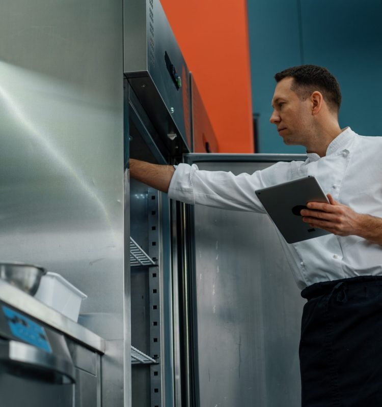 Professional chef using tablet computer recipes while working in modern kitchen cooking concept