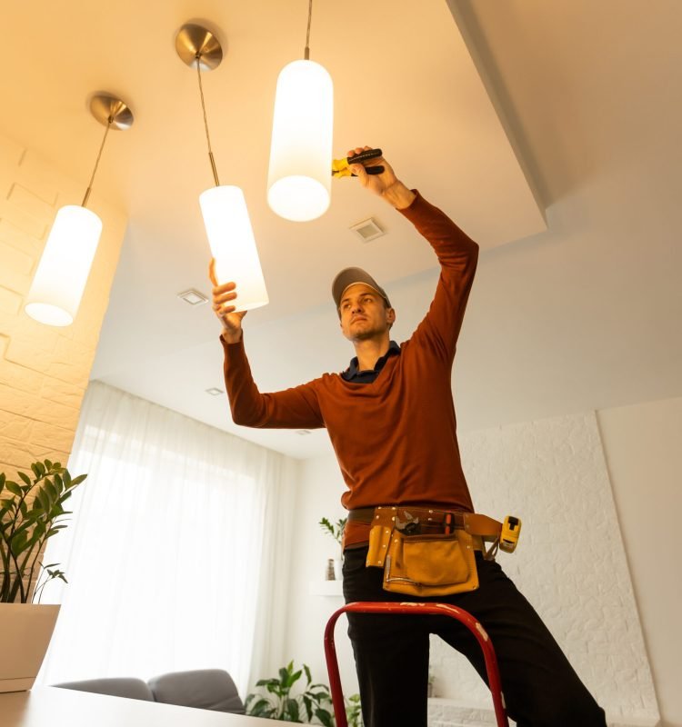 Electrician man working on exterior light, install LED replacement lamp at home. Maintenance concept
