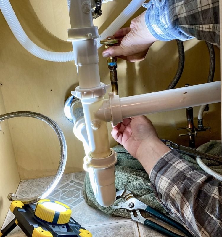 plumber-repairing-sink-plumbing-in-cabinet-with-to-2026-03-16-01-24-31-utc