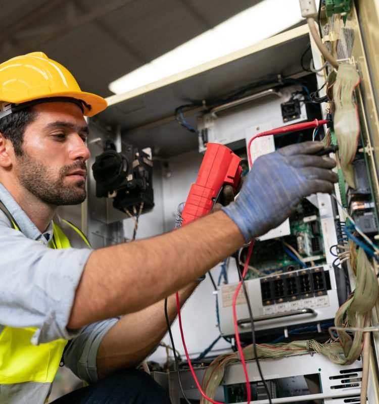 Robotics engineer working on maintenance of modern robotic arm in factory warehouse