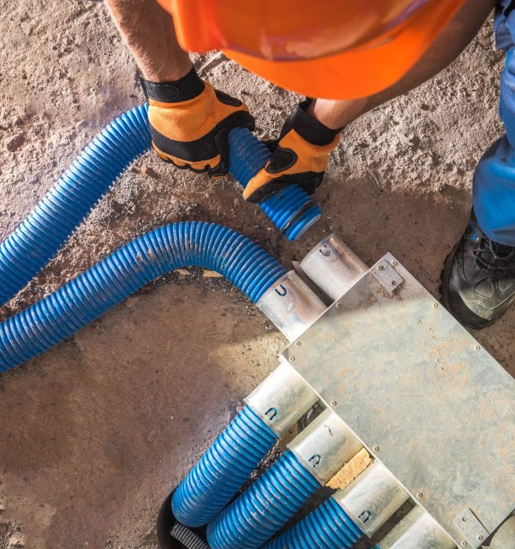 Industrial Theme. Modern Floor Hidden Air Circulation and Climate Control Pipeline Installation. Pipes Hub Finishing by Caucasian Climate Control Technician in His 40s.